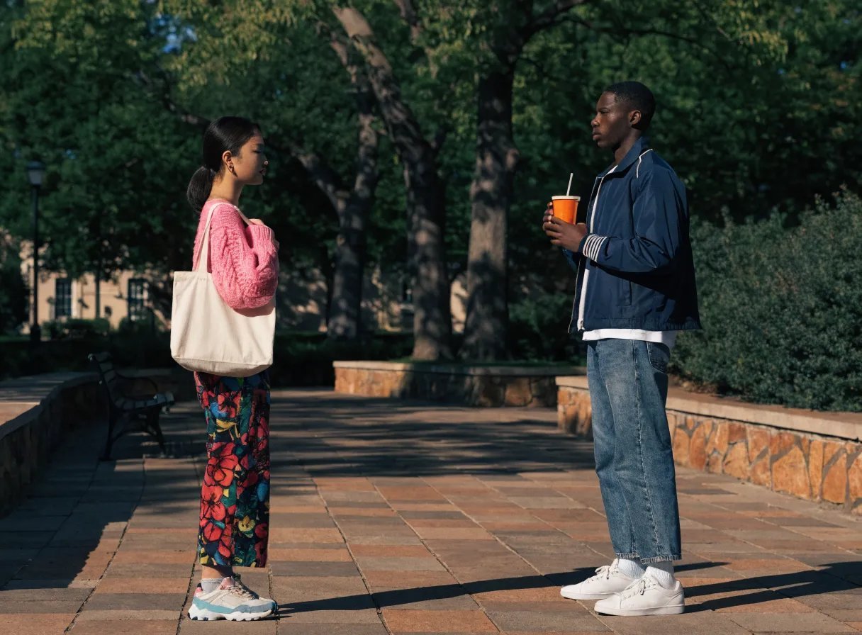 A couple standing in a park, holding hands and enjoying a moment together